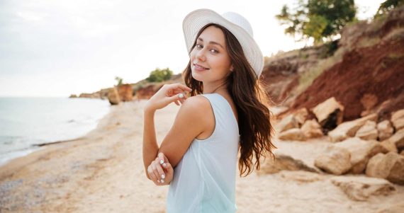 happy-young-woman-in-white-hat-waalking-near-the-PMPGEFG.jpg